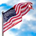 A photo of an American flag waving in the wind.